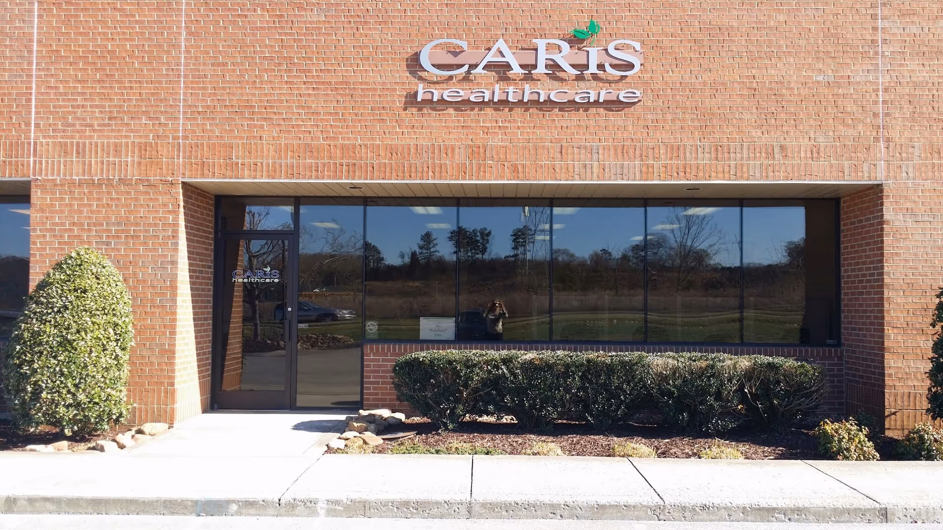 Brick building facade with Caris Healthcare signage and glass entrance
