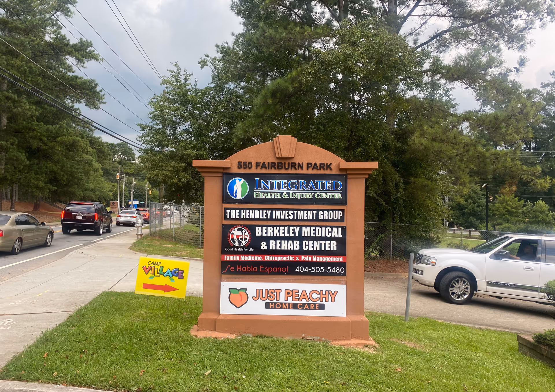 A tall brick roadside sign displays Just Peachy Home Care and other businesses.