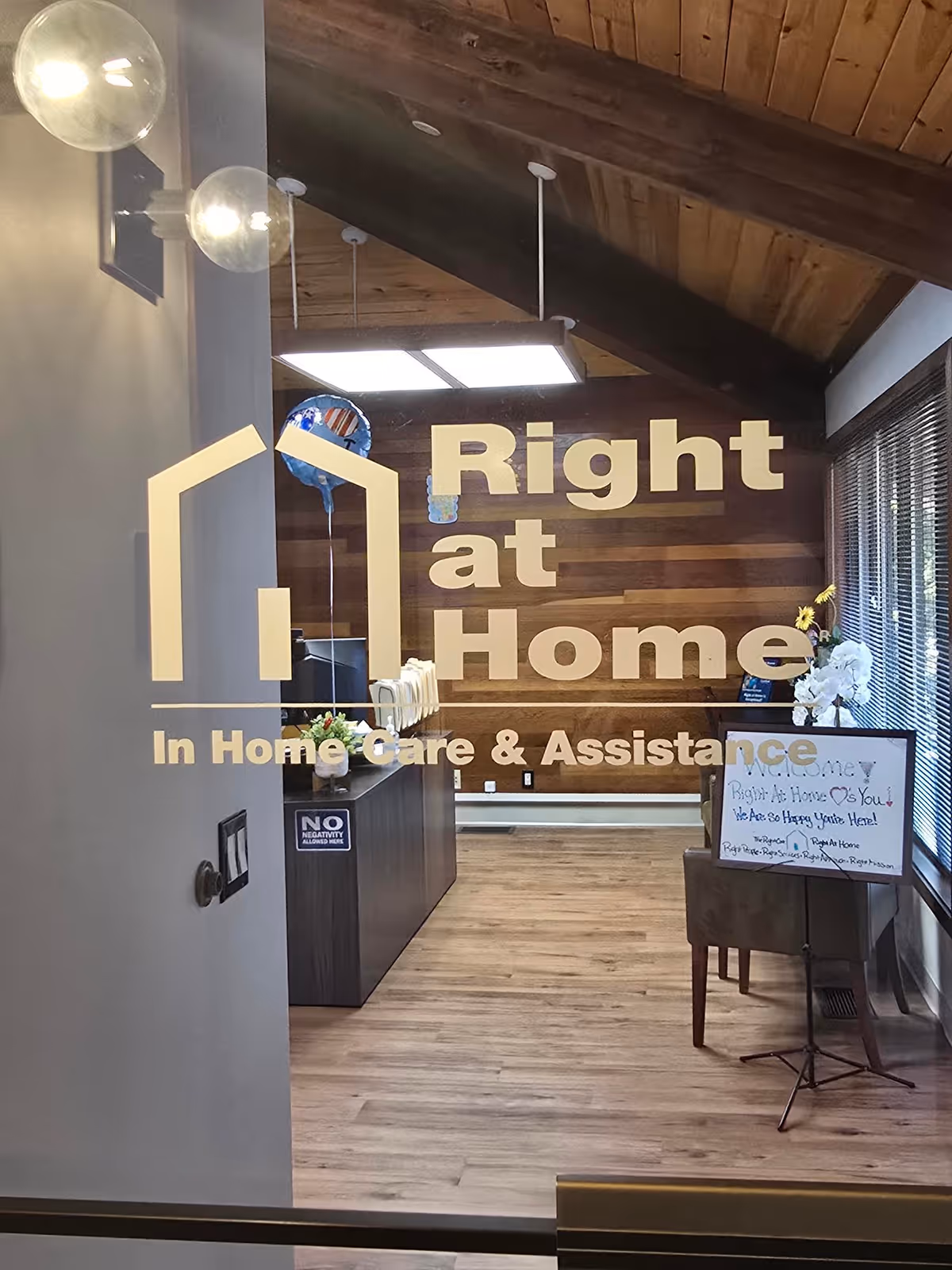 Reception area with Right at Home sign, wooden ceiling, and welcome board.