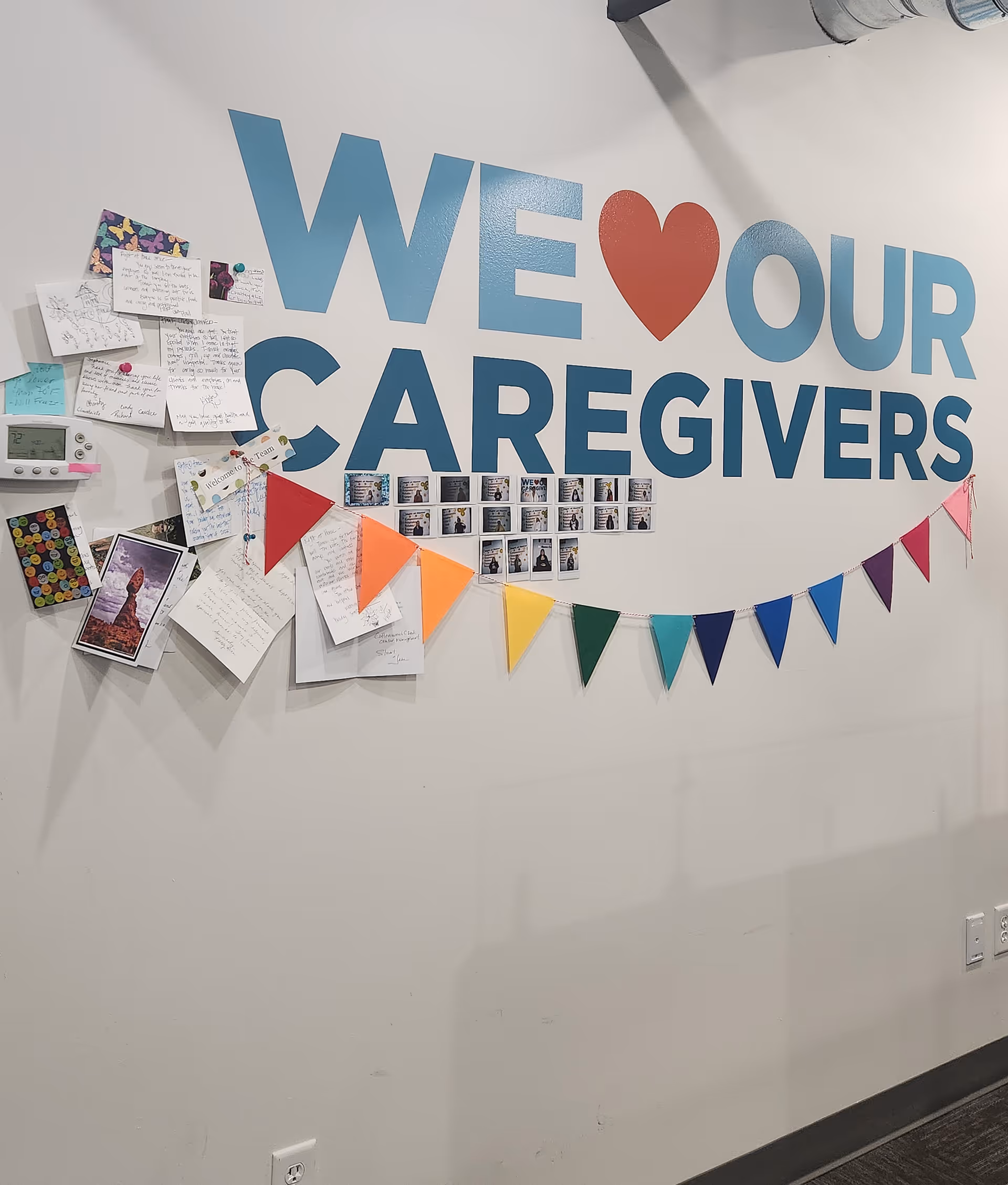 Interior wall displays a large 'WE HEART OUR CAREGIVERS' sign with notes and bunting.