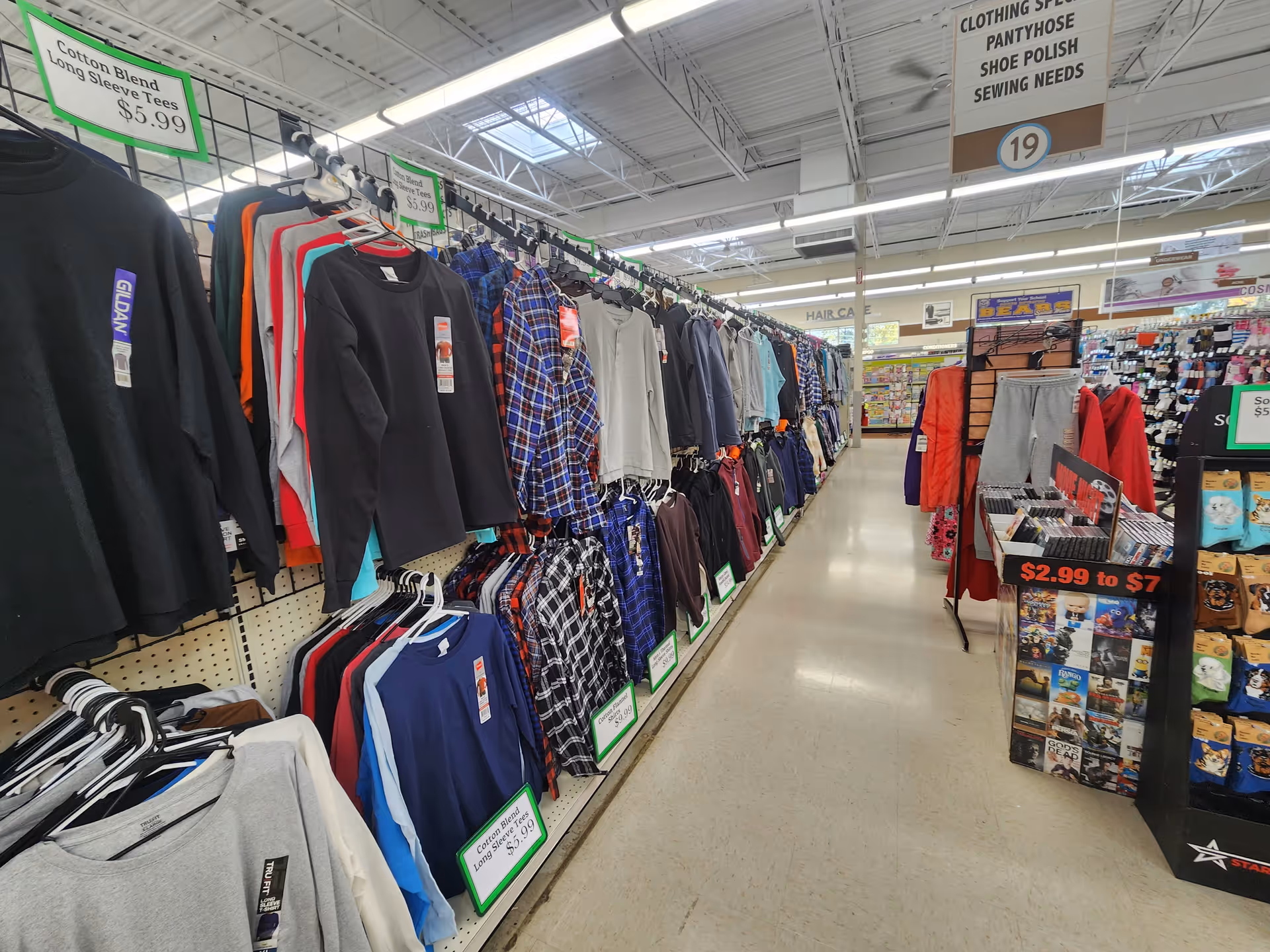 Long aisle of clothing racks with shirts and jackets in a store