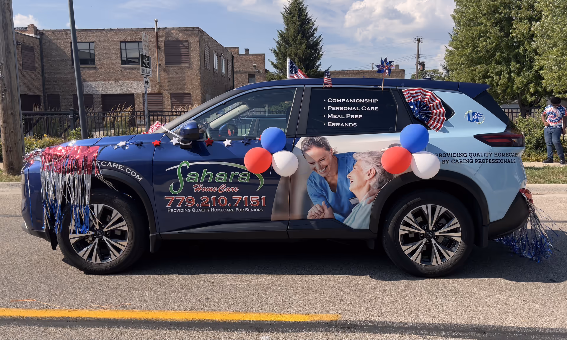 Decorated Sahara Home Care promotional SUV parked on a street with patriotic banners.