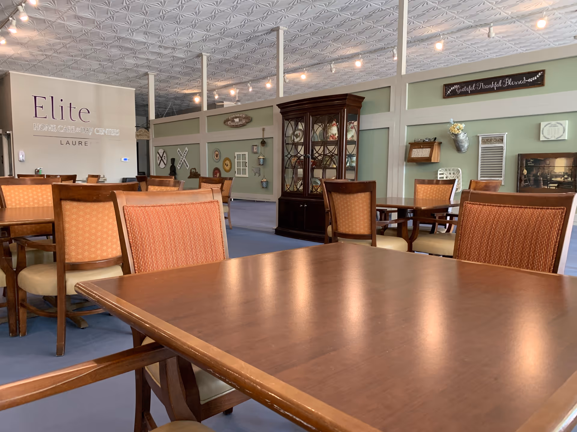 Interior dining hall at Elite Home Care and Day Centers with wooden tables and chairs