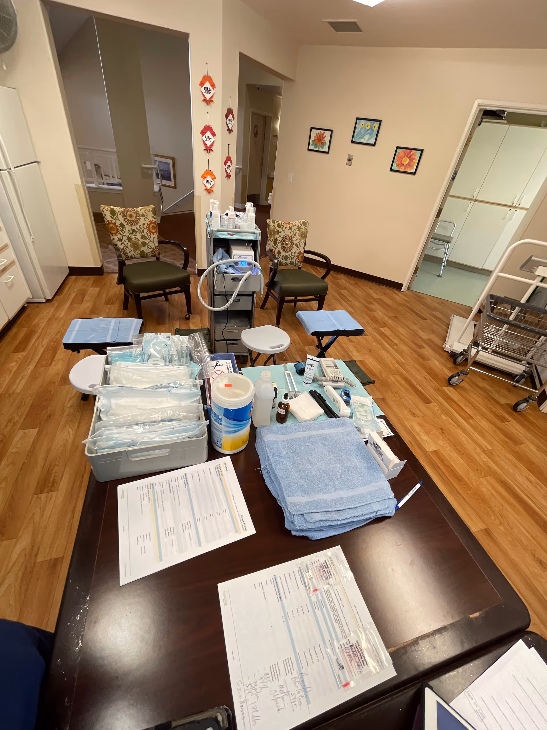 Clinic-style podiatry treatment room with medical supplies on a table and seating around.