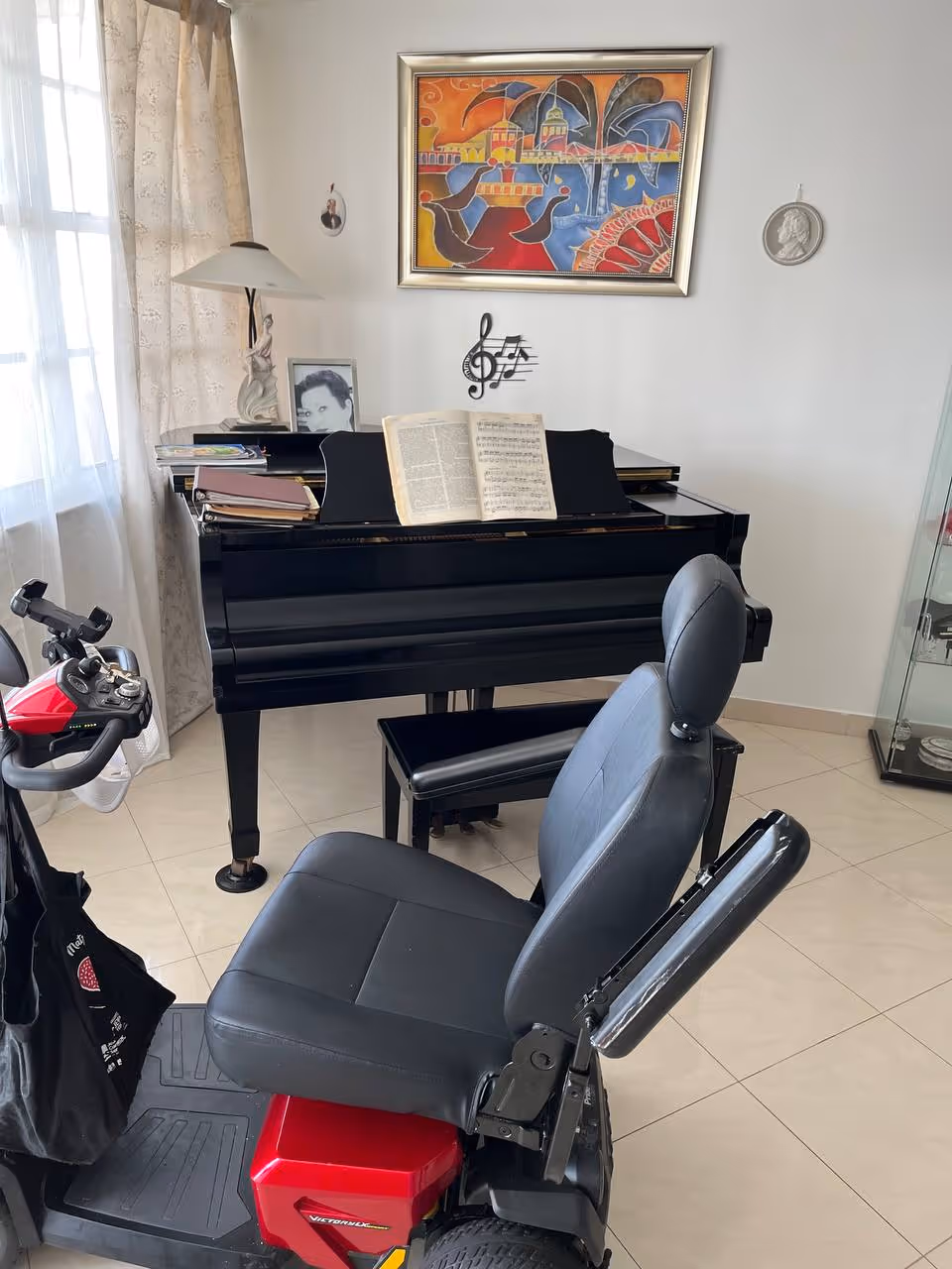 Black grand piano with sheet music in a bright, tiled living room corner.