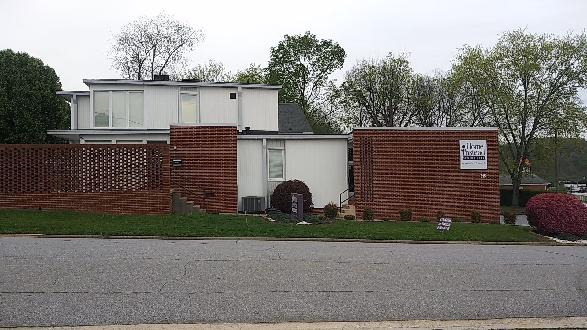 Exterior of a Home Instead senior care facility with brick walls and a sign