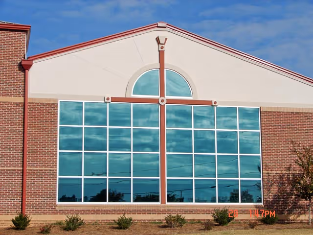 Front view of a brick assisted living facility with large glass windows.