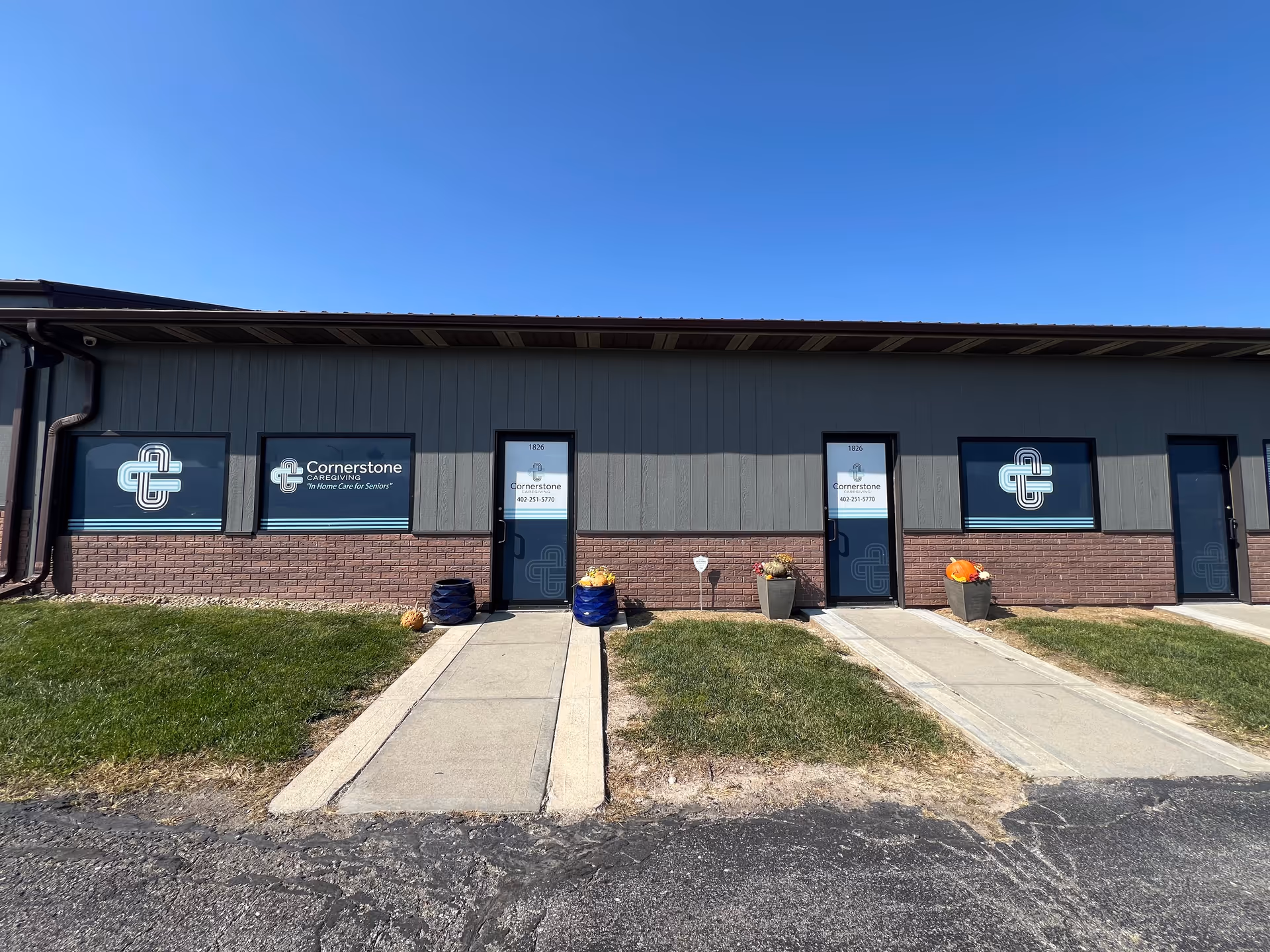 Exterior view of Cornerstone Caregiving facility with front doors, windows, and planters.