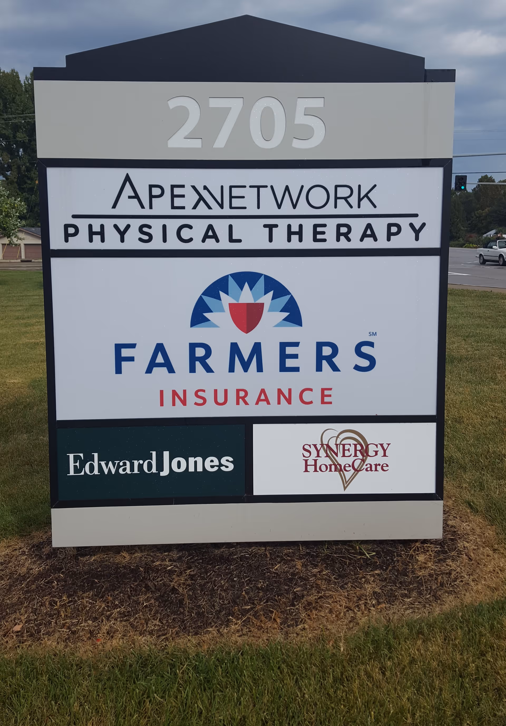Outdoor signboard displaying 2705 address and multiple logos, including Synergy HomeCare.