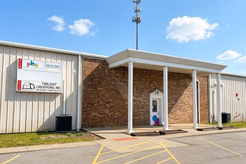 Exterior view of a brick building entrance with a white canopy.