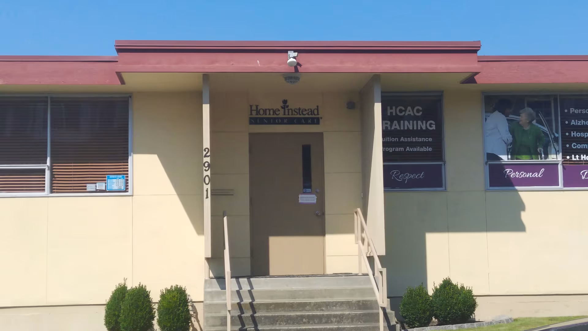 Front exterior of a Home Instead senior care building with steps and signage.