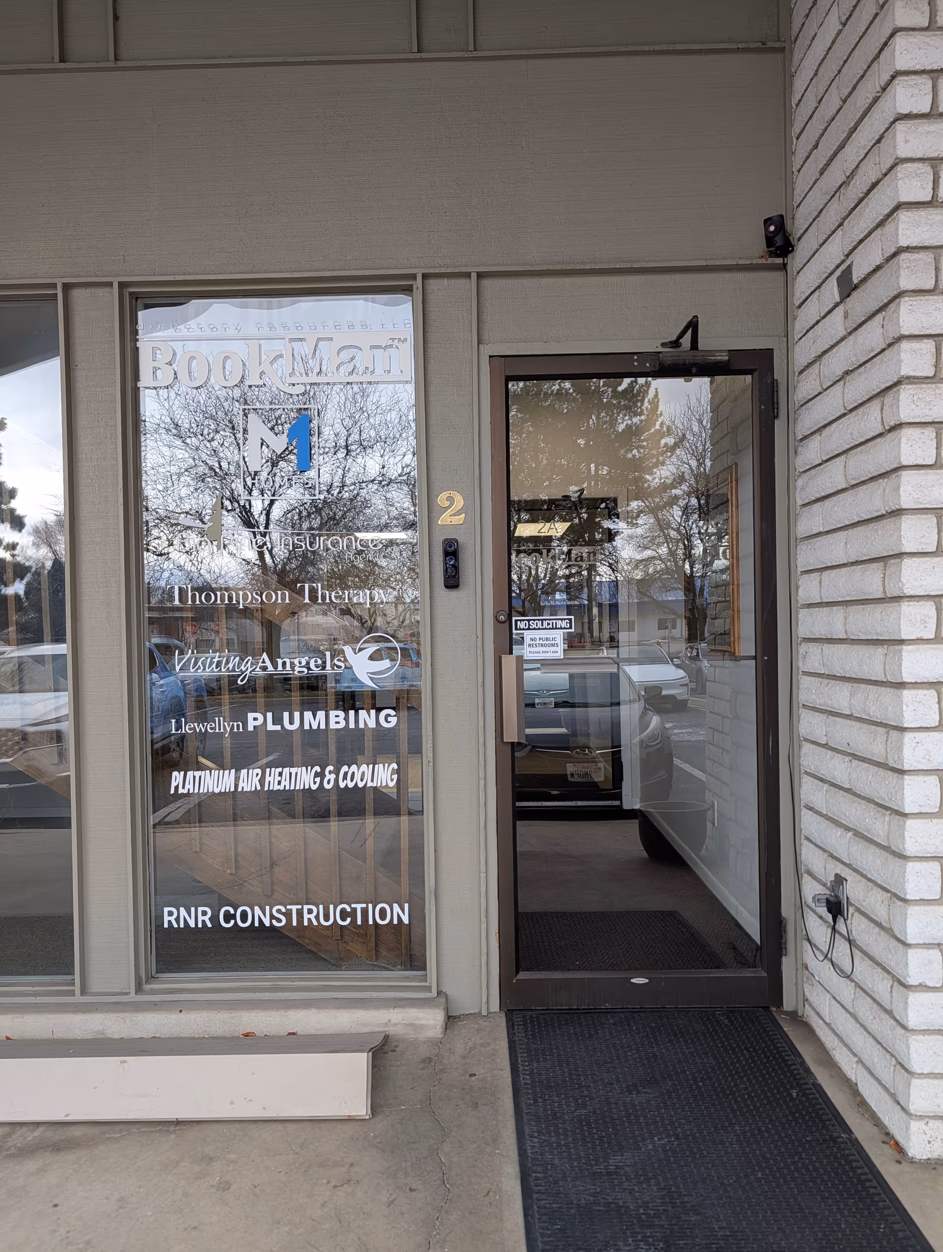 Front entrance of building with glass door and window displaying Visiting Angels Senior Home Care signage.