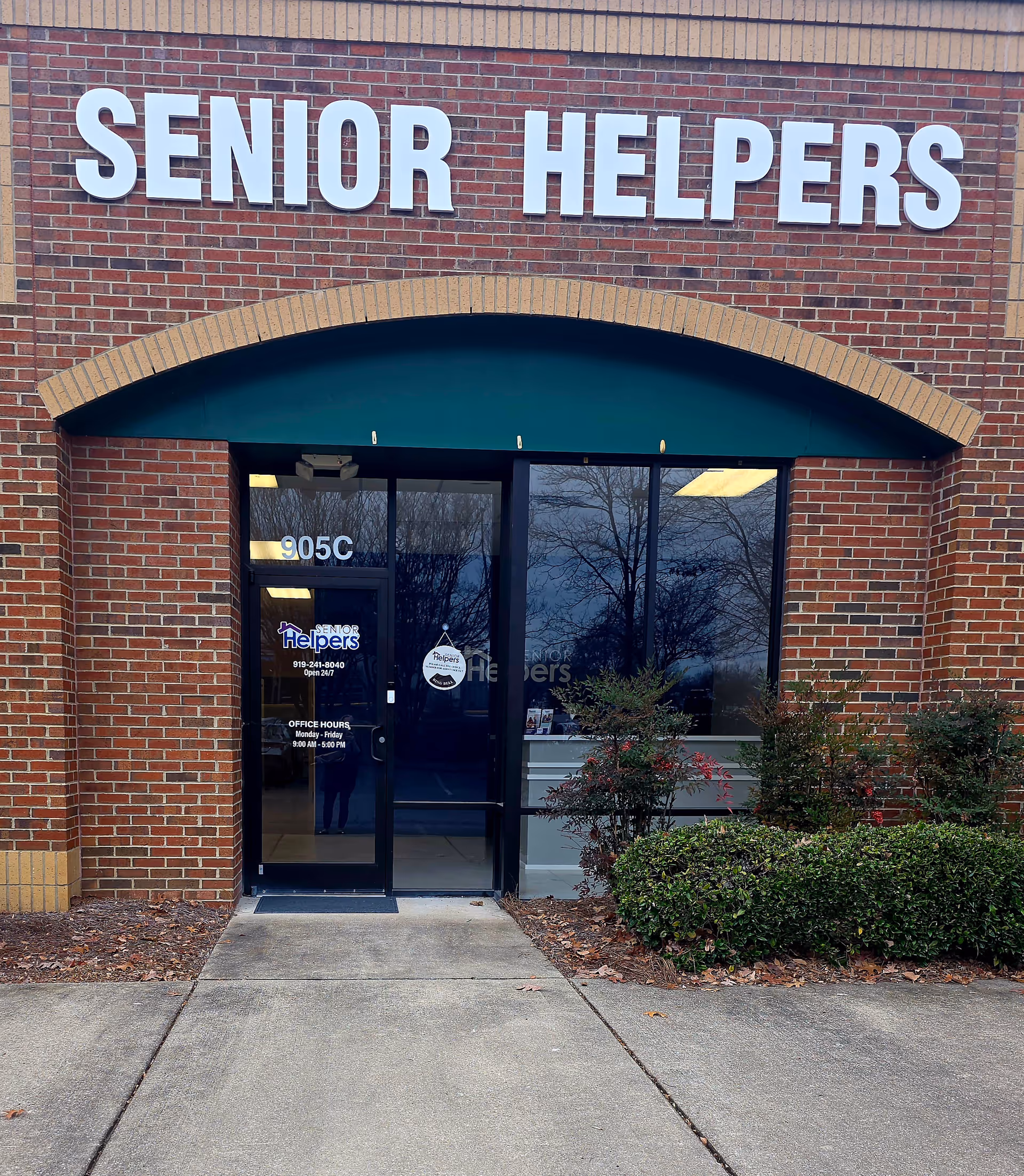 Front entrance to Senior Helpers facility with brick exterior and glass doors.