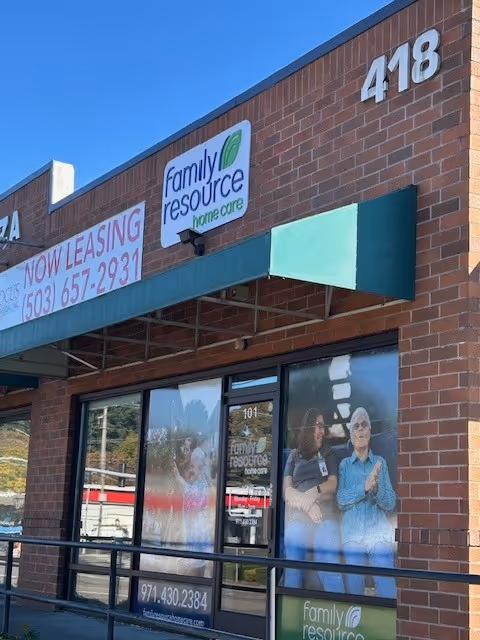Brick storefront with Family Resource Home Care sign and large window posters.