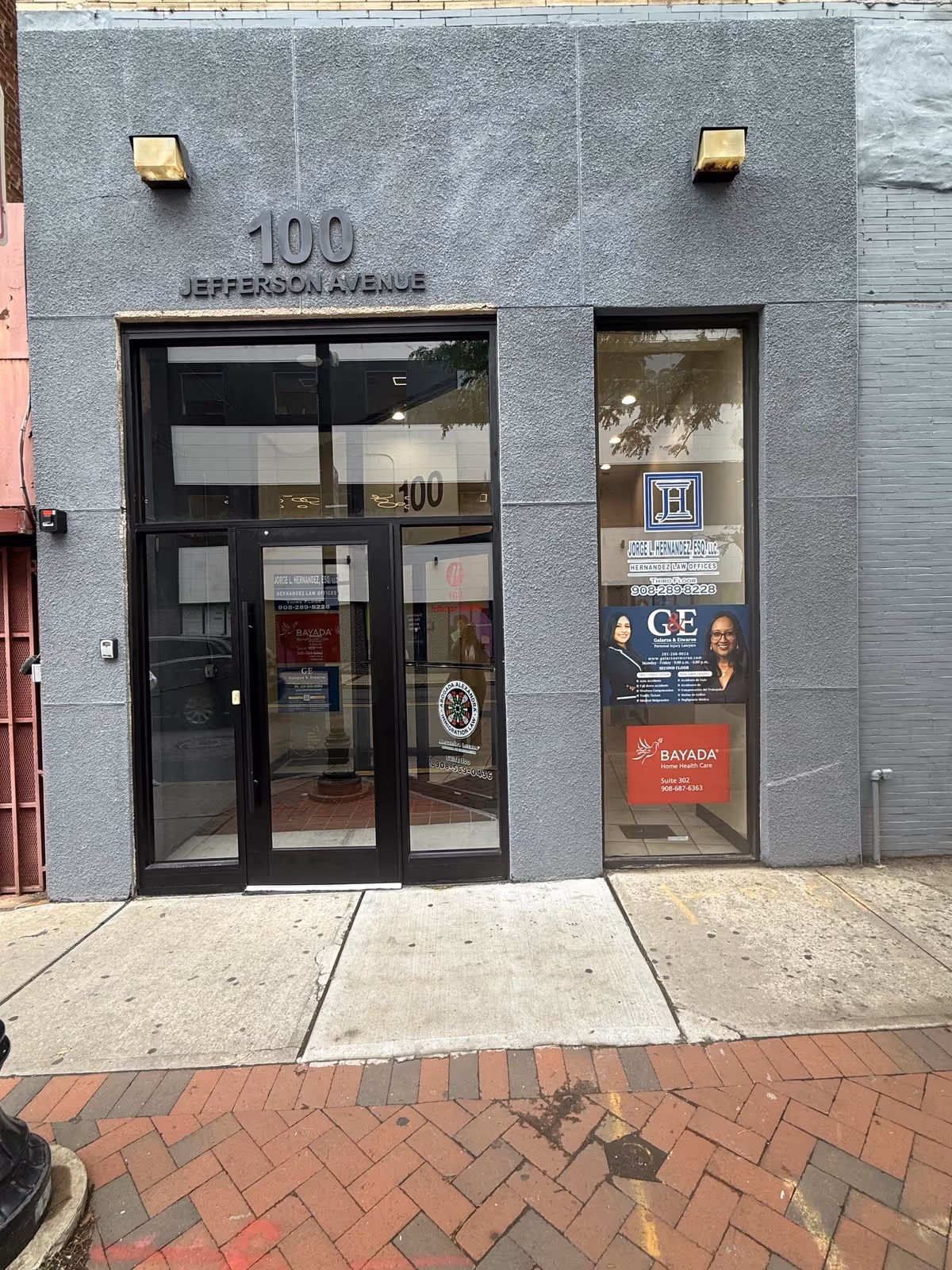Exterior storefront with glass doors and the address 100 Jefferson Avenue.