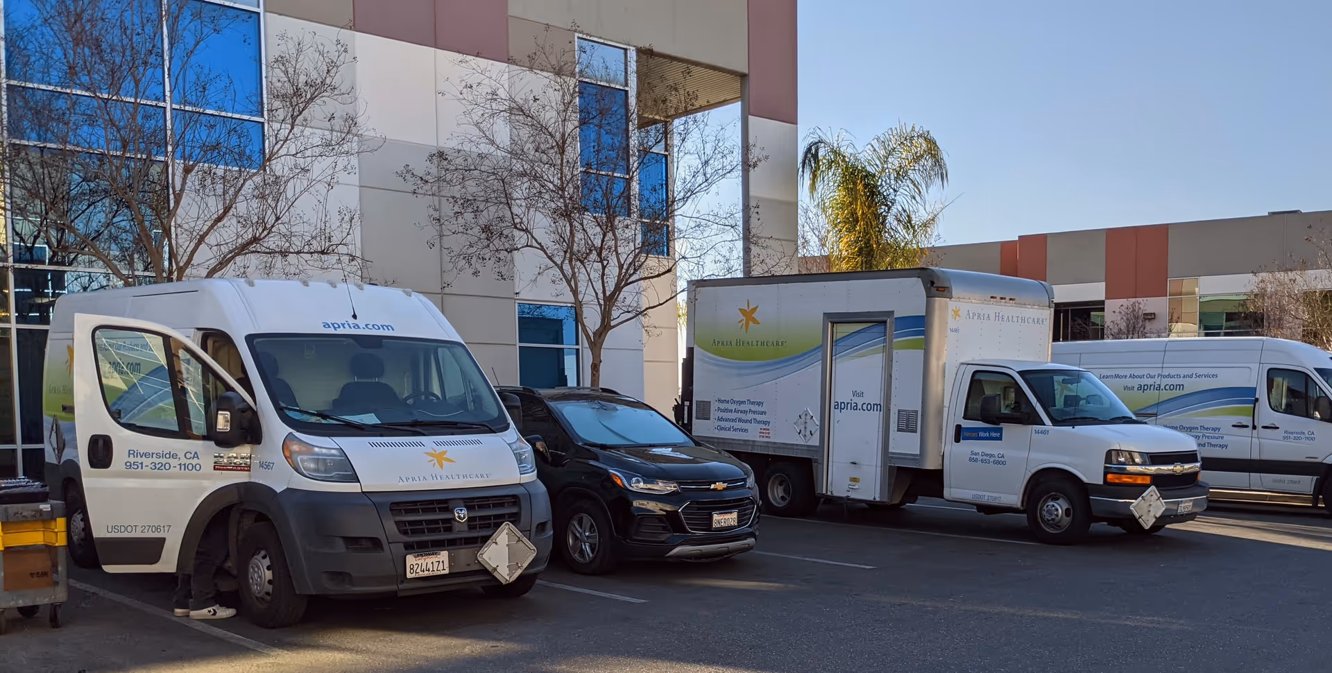 Front of a senior living facility with Apria Healthcare service vans in parking lot