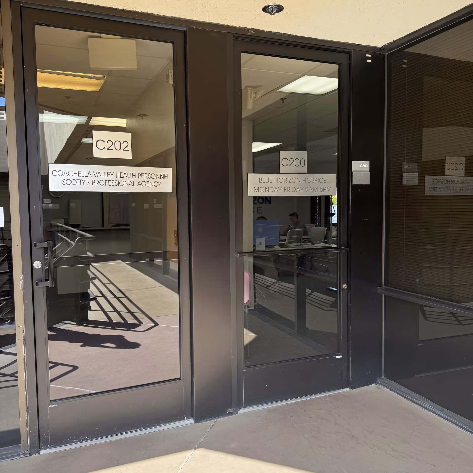 Glass front entrance with Blue Horizon Hospice signs and interior desk visible