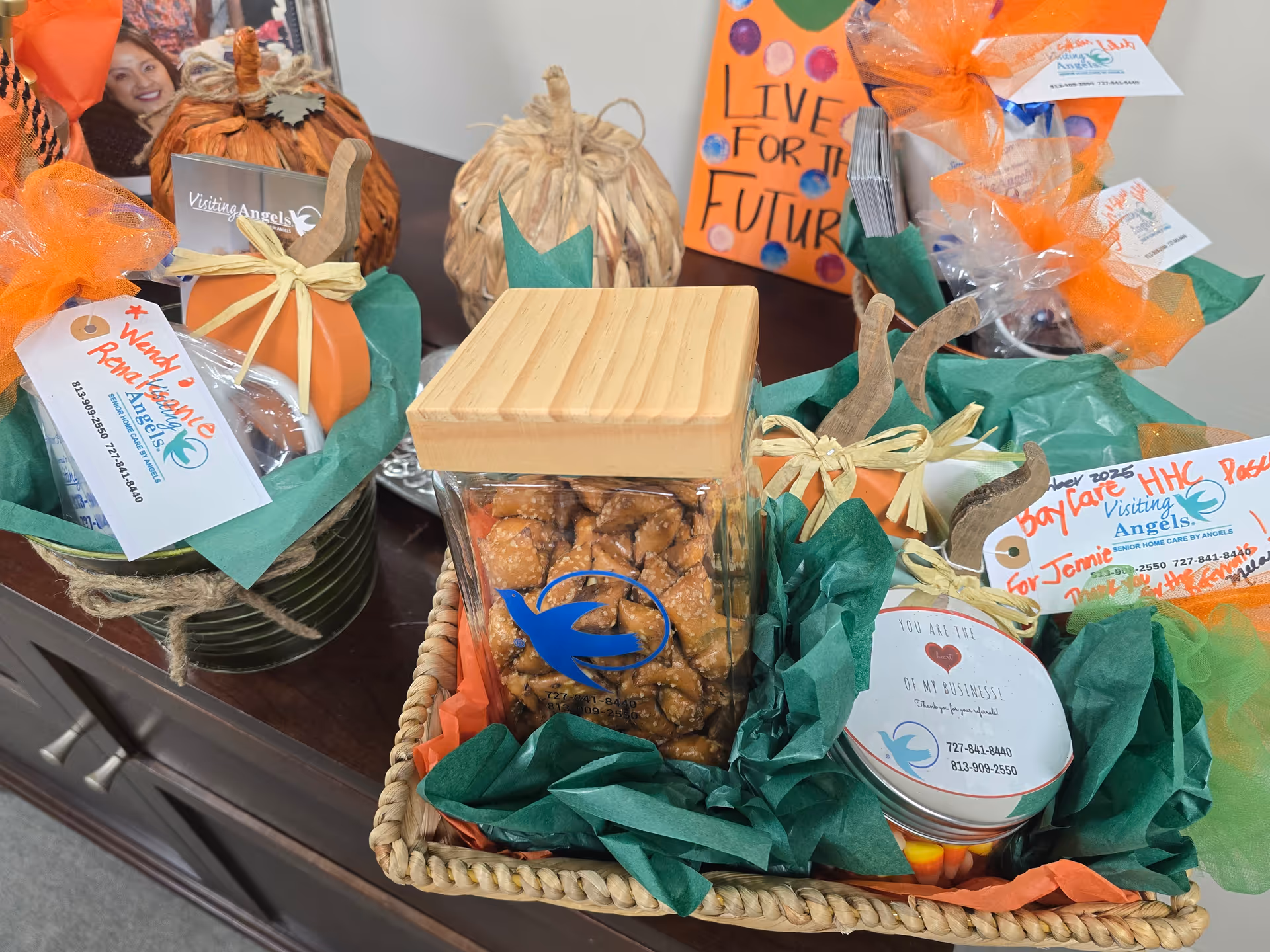 Gift baskets and decorative pumpkins arranged on a table inside a senior care facility.
