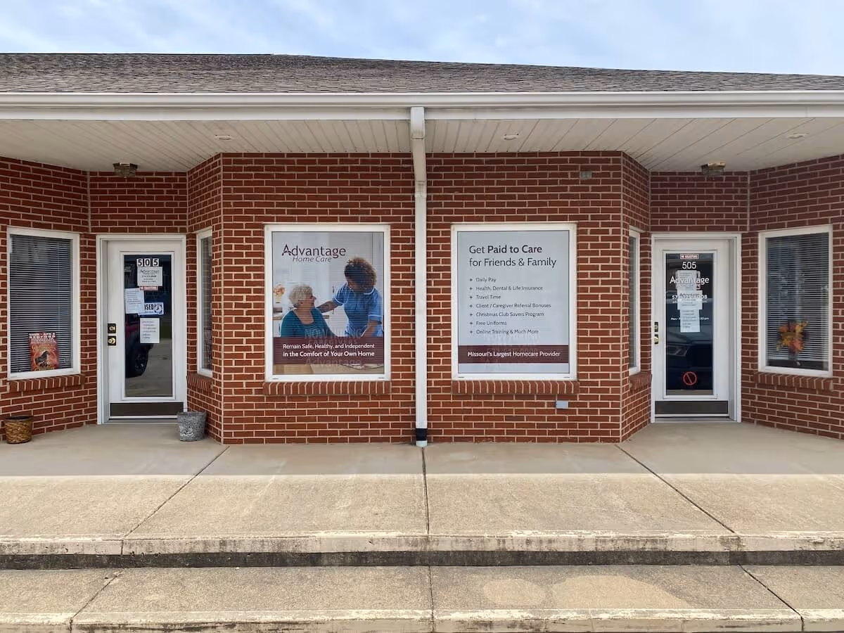 Brick storefront with three windows and doors displaying Advantage Home Care signage.