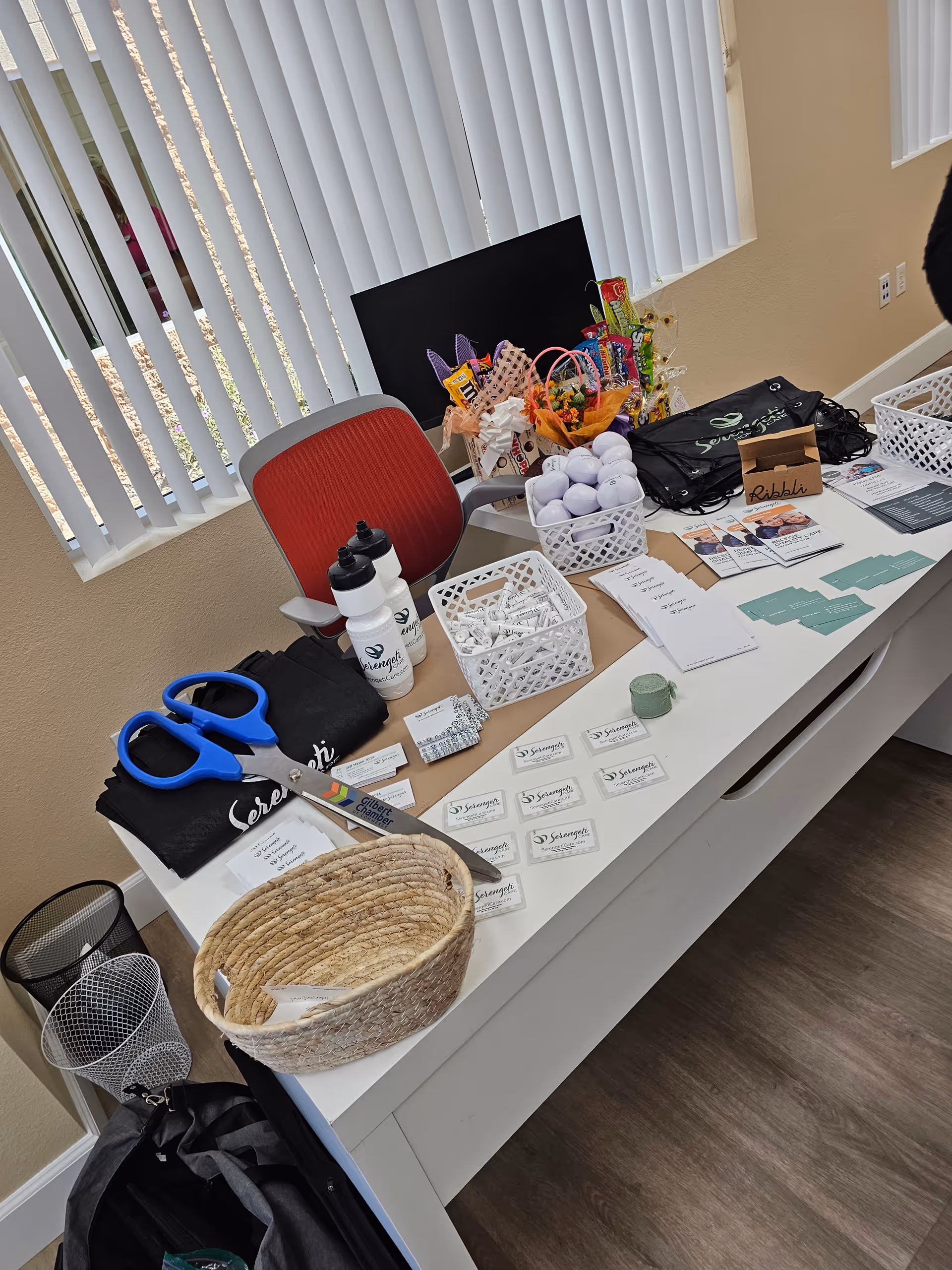 Indoor counter with scissors, baskets, water bottles, cards, and promotional materials.