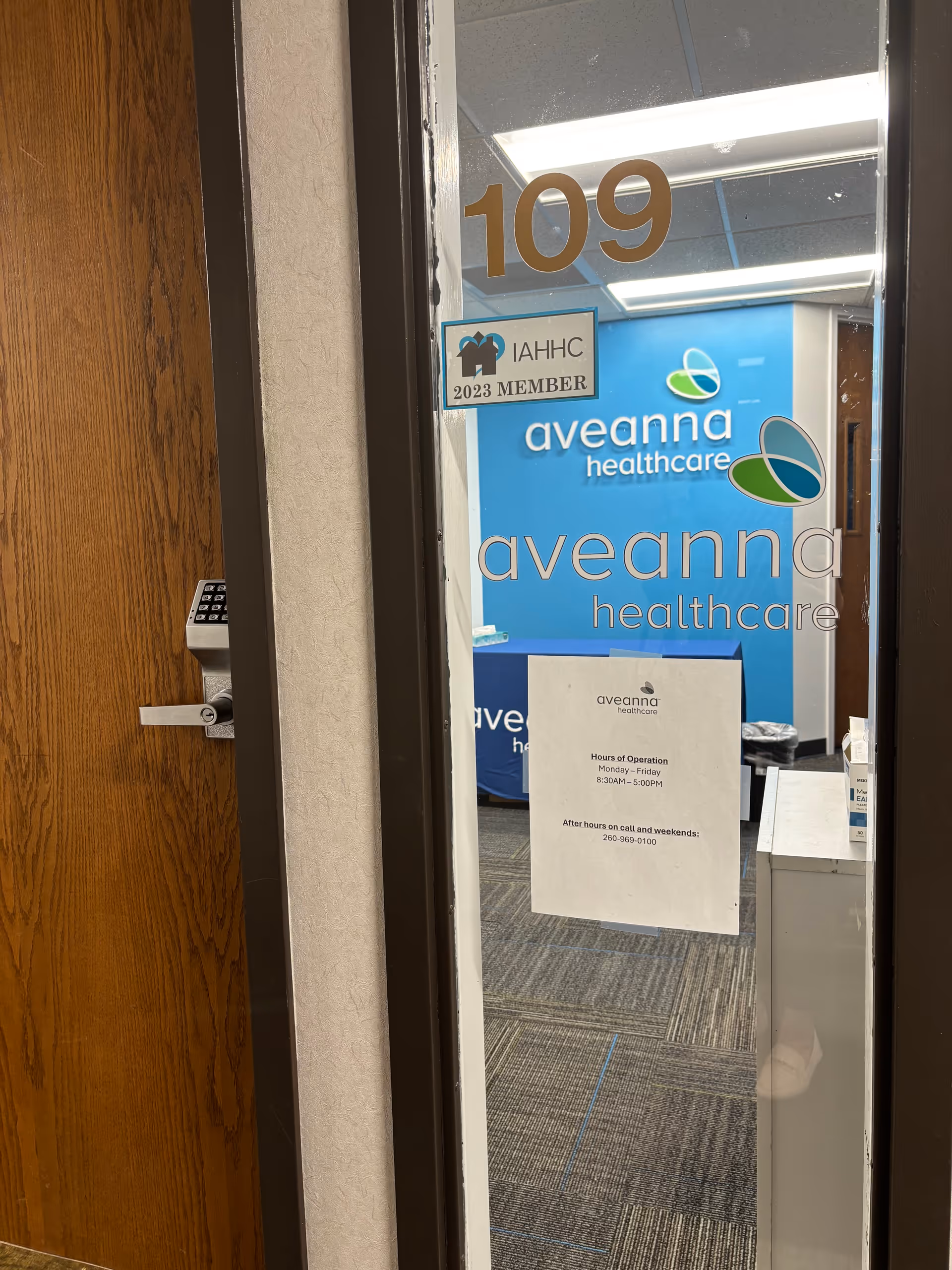 Interior doorway with Aveanna Healthcare signage and a blue office banner.