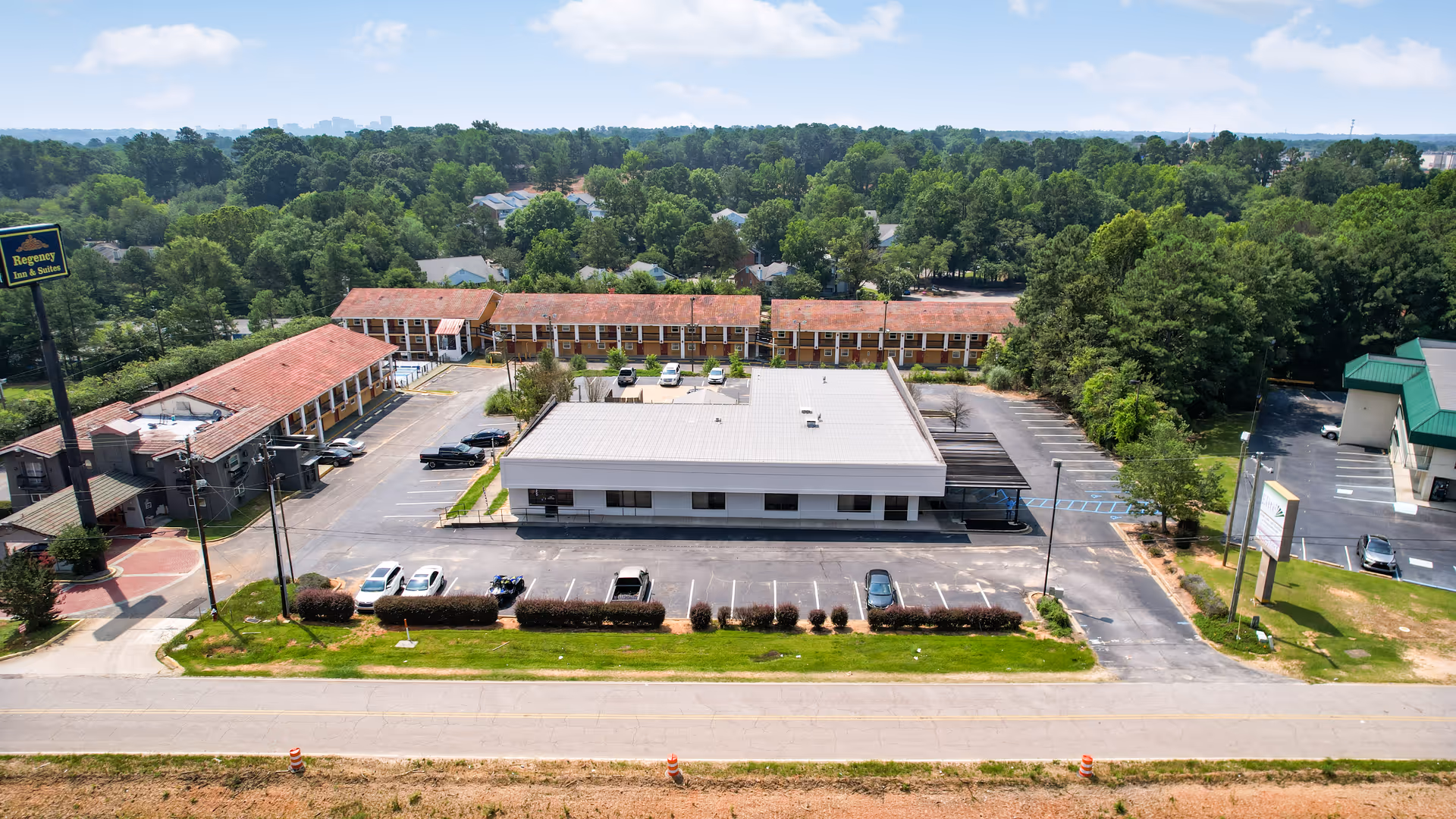 Aerial view of a multi-building senior living facility with parking and surrounding trees.