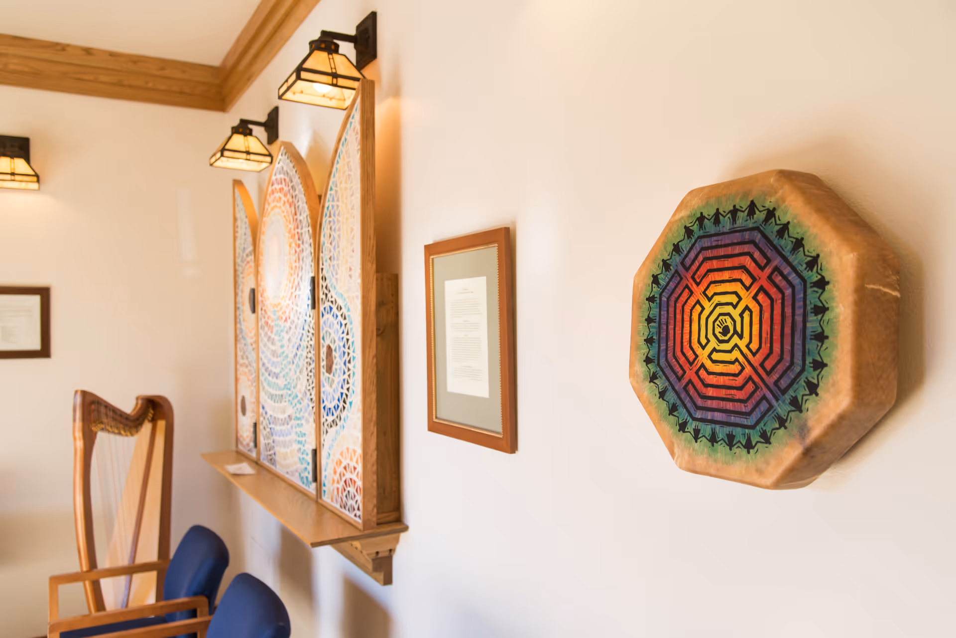 A warmly lit hallway with colorful wall art and framed documents.