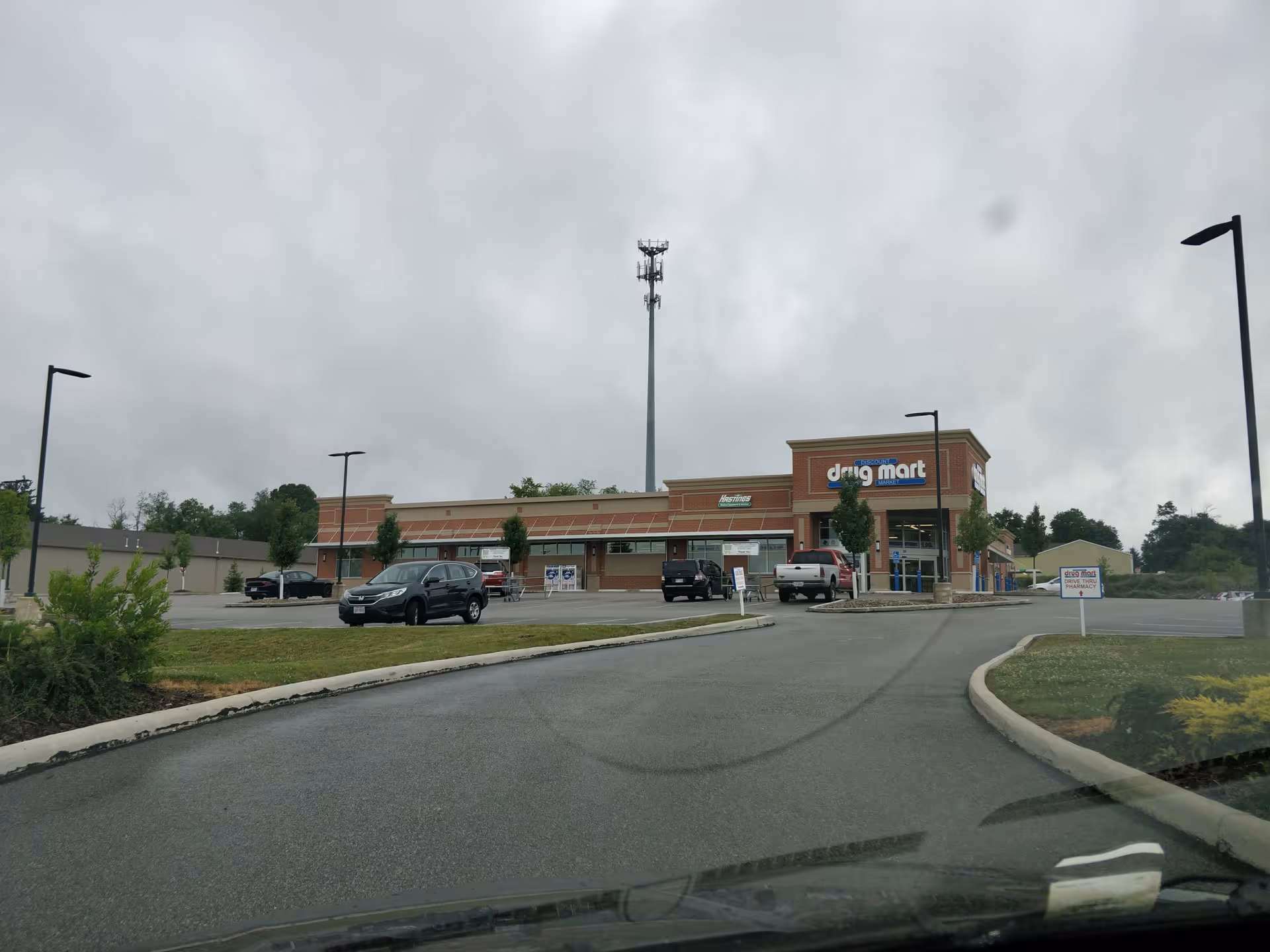 Discount Drug Mart storefront with parking lot and cloudy sky in the background.