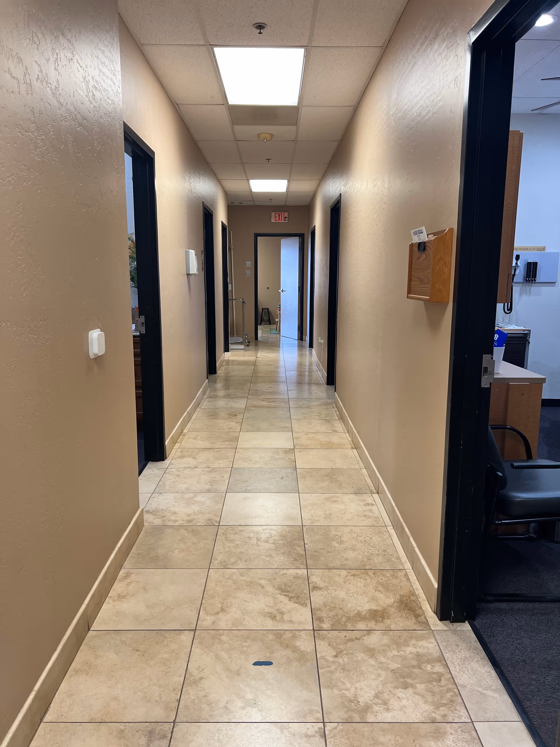 Long beige hallway in a senior living facility with doors on both sides.