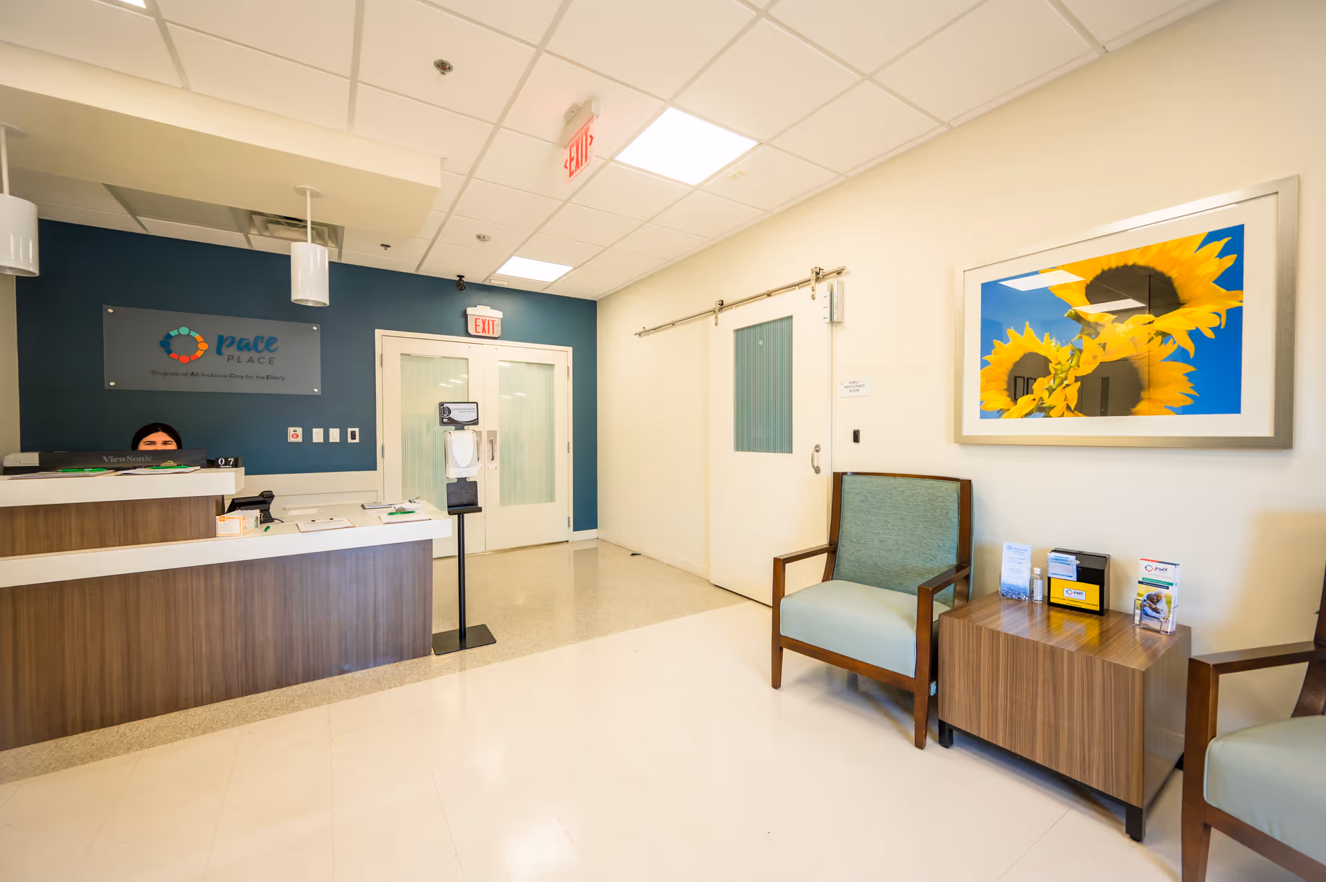 Reception area of The PACE Place with a desk, seating, and sunflower artwork.