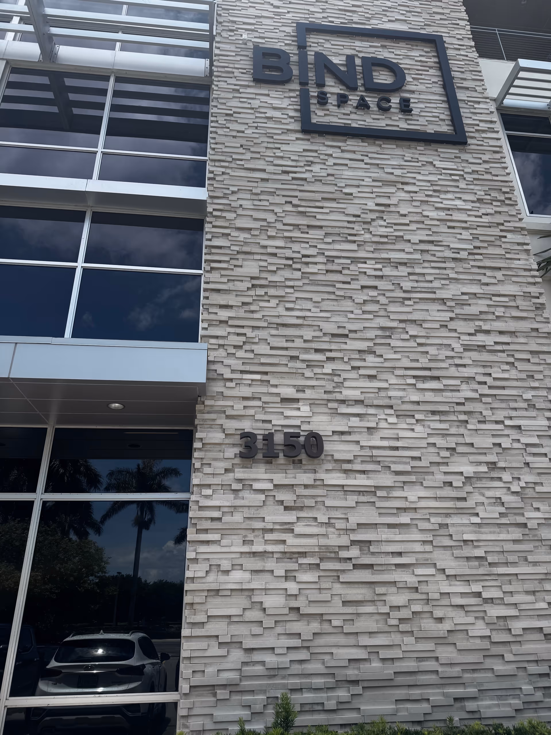 Exterior view of a stone-clad building with large windows and the BND SPACE sign.