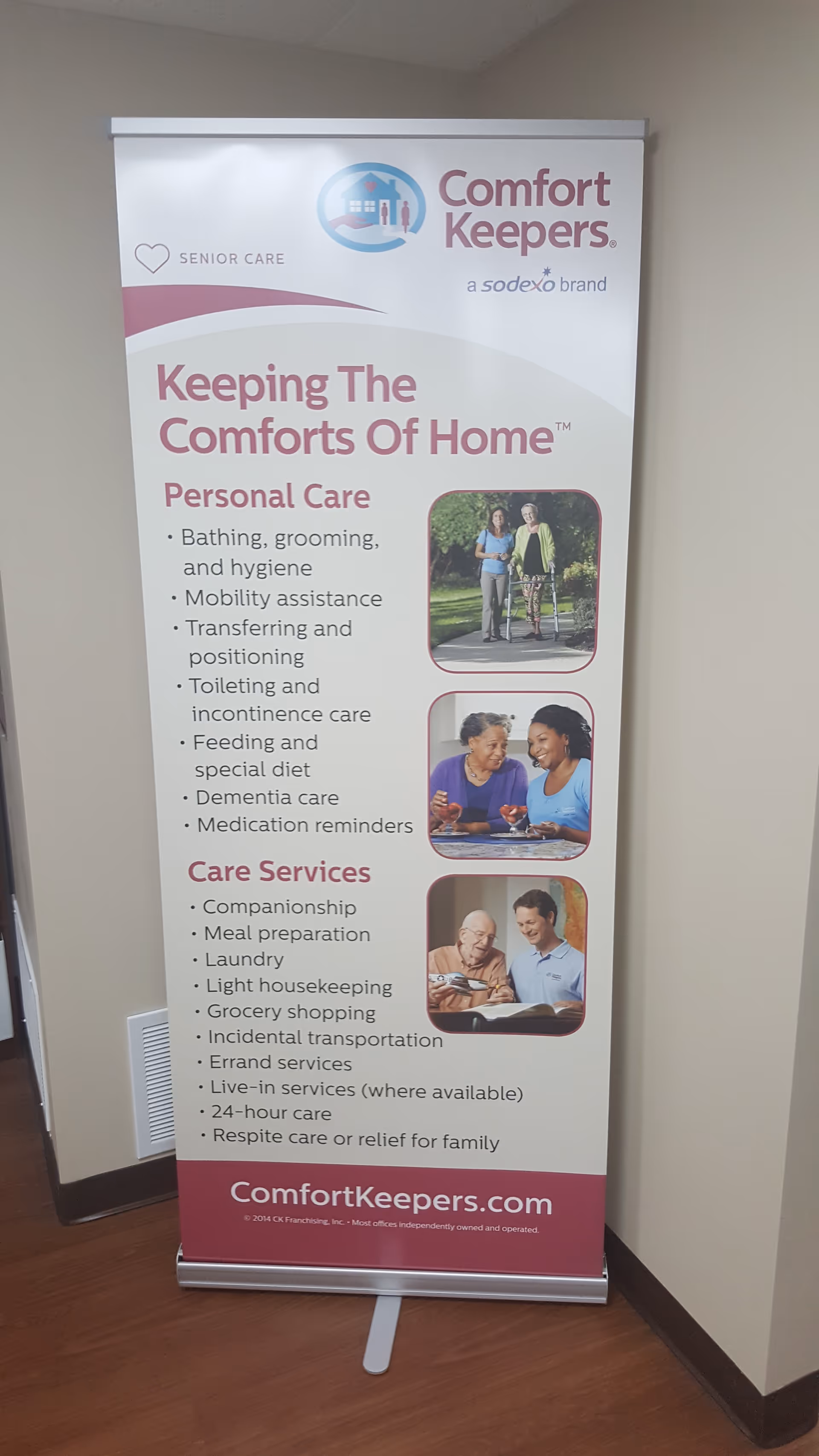 A Comfort Keepers banner stands in a hallway advertising personal care services.