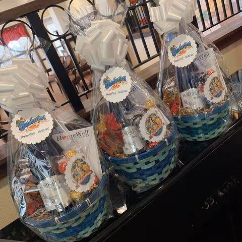Gift baskets wrapped in cellophane with ribbons on a counter.