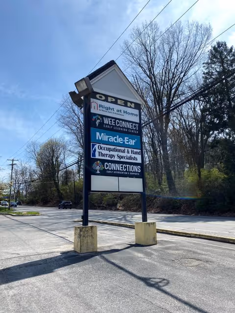 Outdoor signboard advertising Right at Home and partner services beside a parking lot.