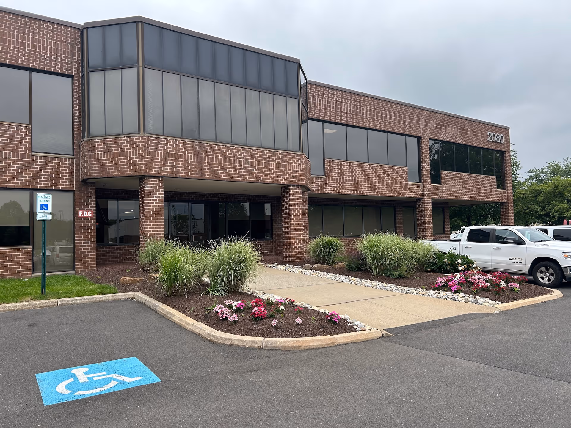 Brick senior care facility exterior with entrance and parking lot in view.