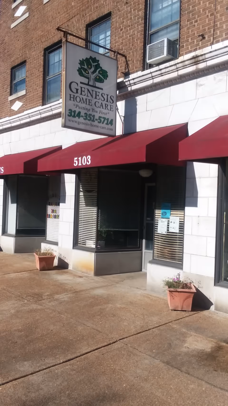 Exterior view of Genesis Home Care storefront with red awnings and planters.