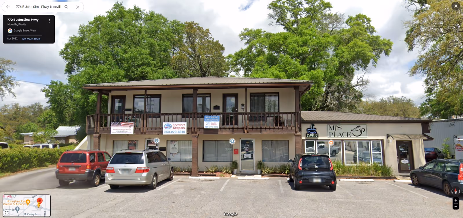 Two-story commercial building housing Comfort Keepers Home Care, with parked cars in front.