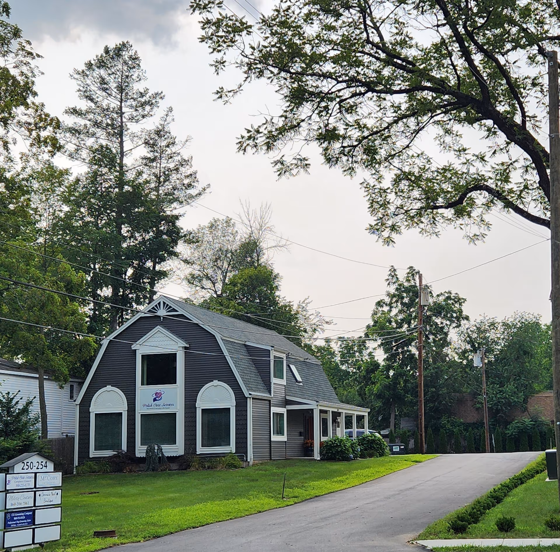 A gray care facility exterior with white trim and Polish Care Services sign.