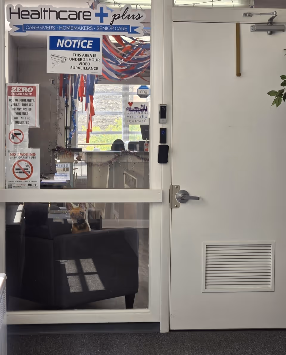 Interior of Healthcare Plus Caregivers with notices on the glass door and a small dog inside.