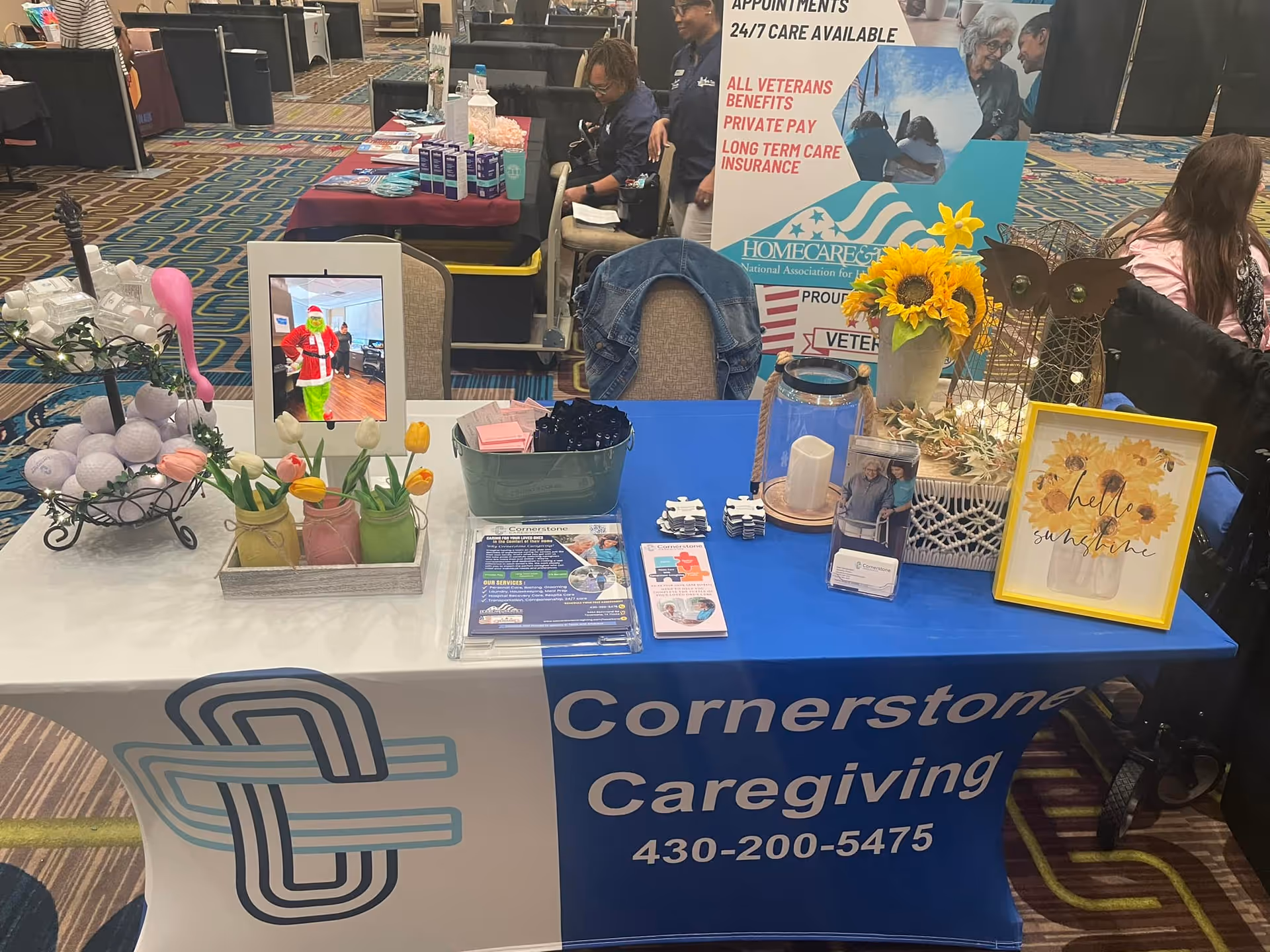 Indoor expo booth for Cornerstone Caregiving with brochures, decorations, and a sunflower display.