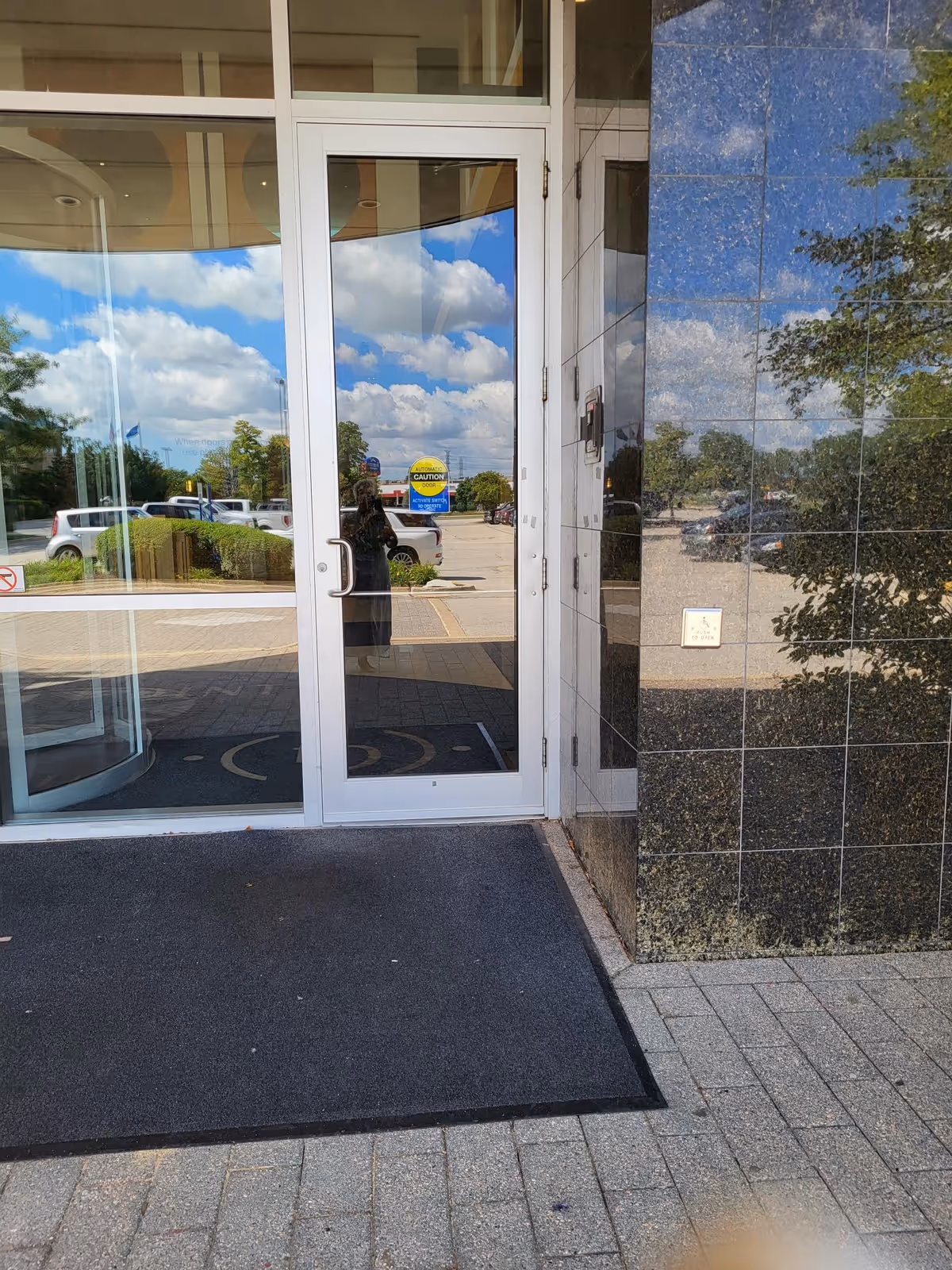 St. Croix Hospice entrance with glass doors and reflections of the blue sky outside.