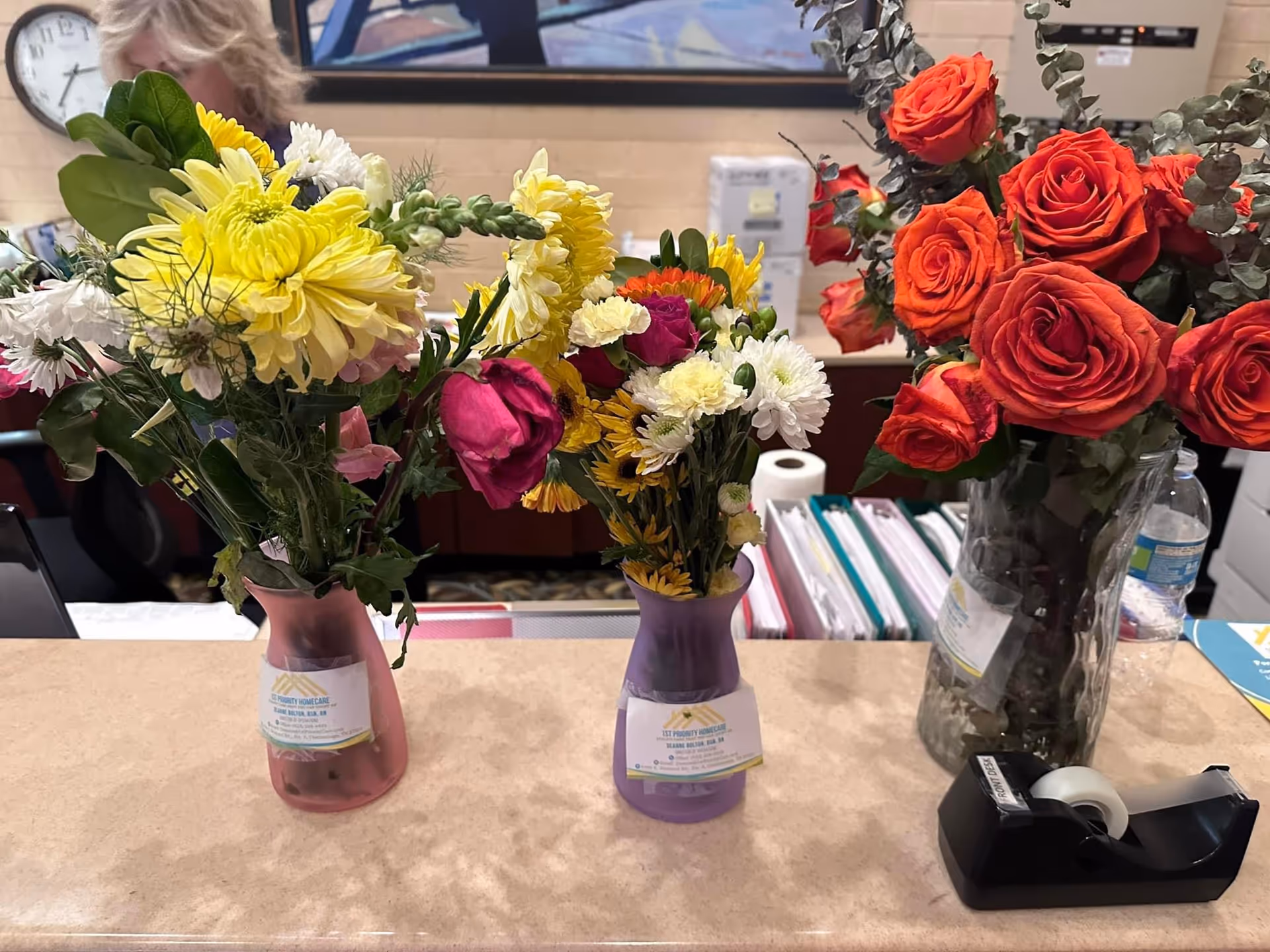 Colorful flower vases on a reception desk inside a senior facility lobby.