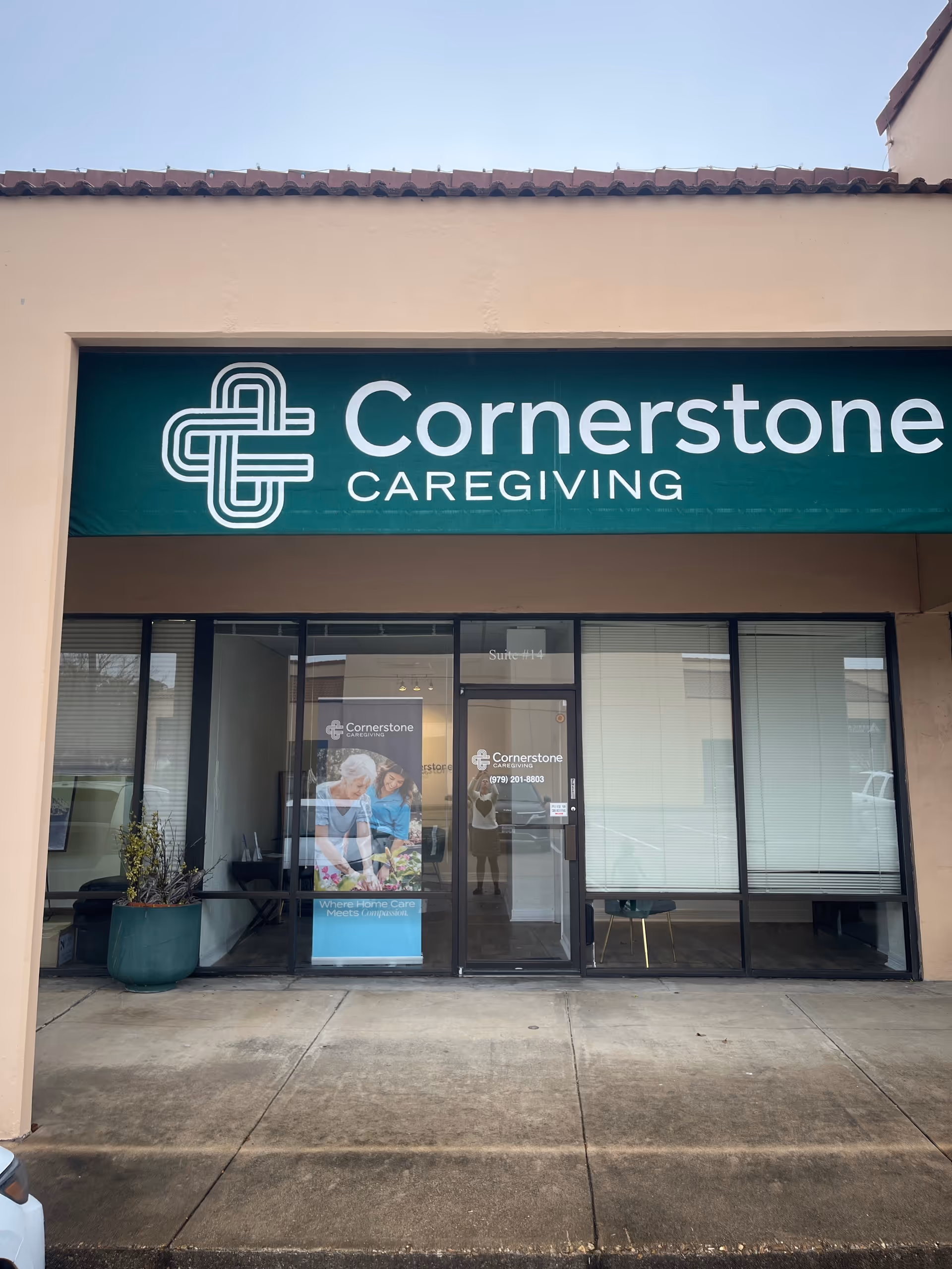 Storefront of Cornerstone Caregiving with teal sign and glass entrance in a strip mall.