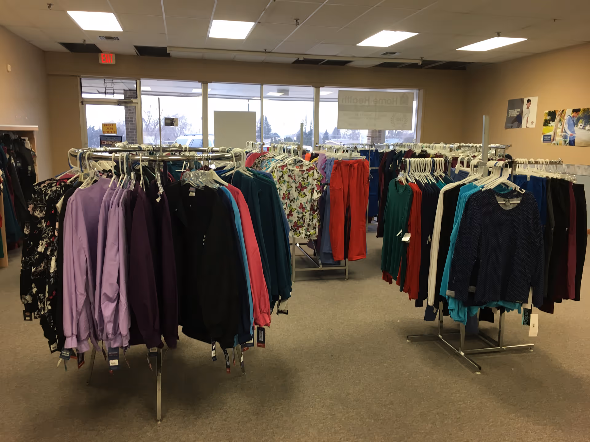 Indoor space with numerous clothing racks displaying colorful jackets and shirts.