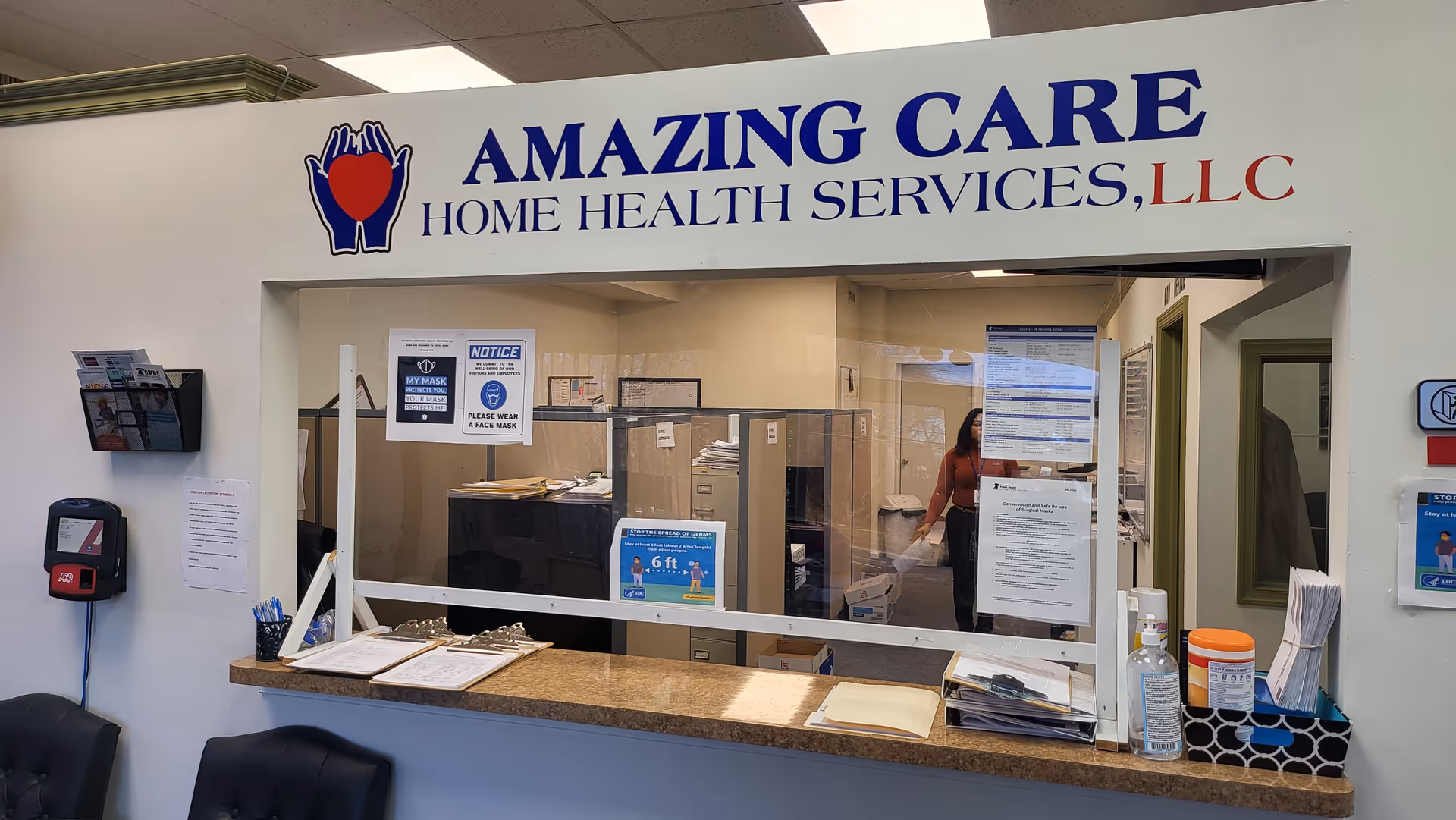 Reception desk inside Amazing Care Home Health Services with staff and notices.