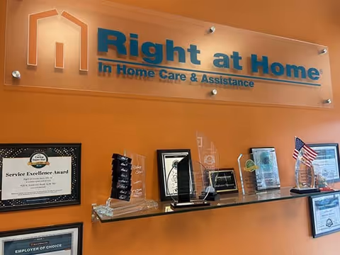 Reception area with awards and a Right at Home sign on an orange wall.