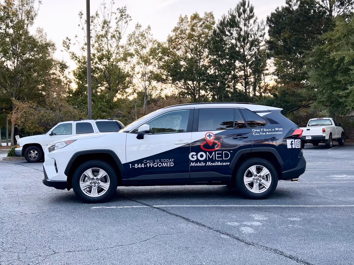 GOMED Mobile Healthcare van parked in a lot with trees in background