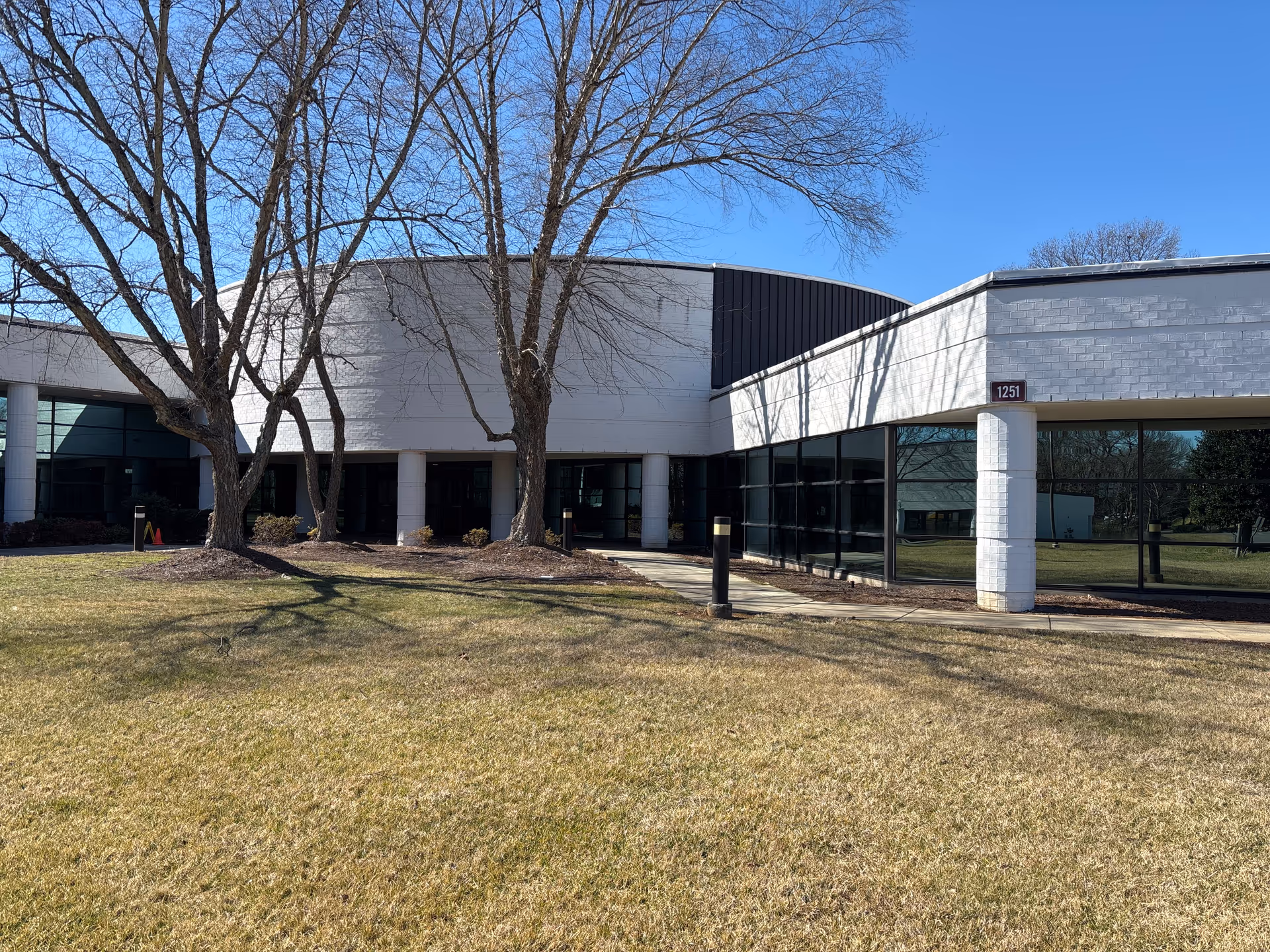 Modern single-story senior care facility exterior with glass storefronts and leafless trees