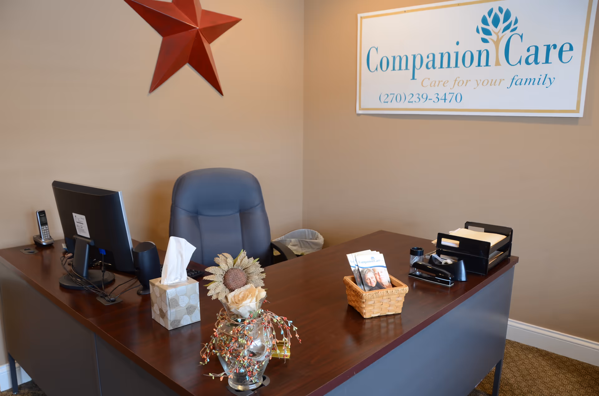 Reception desk with computer, tissue box, decorative items, and a Companion Care sign.