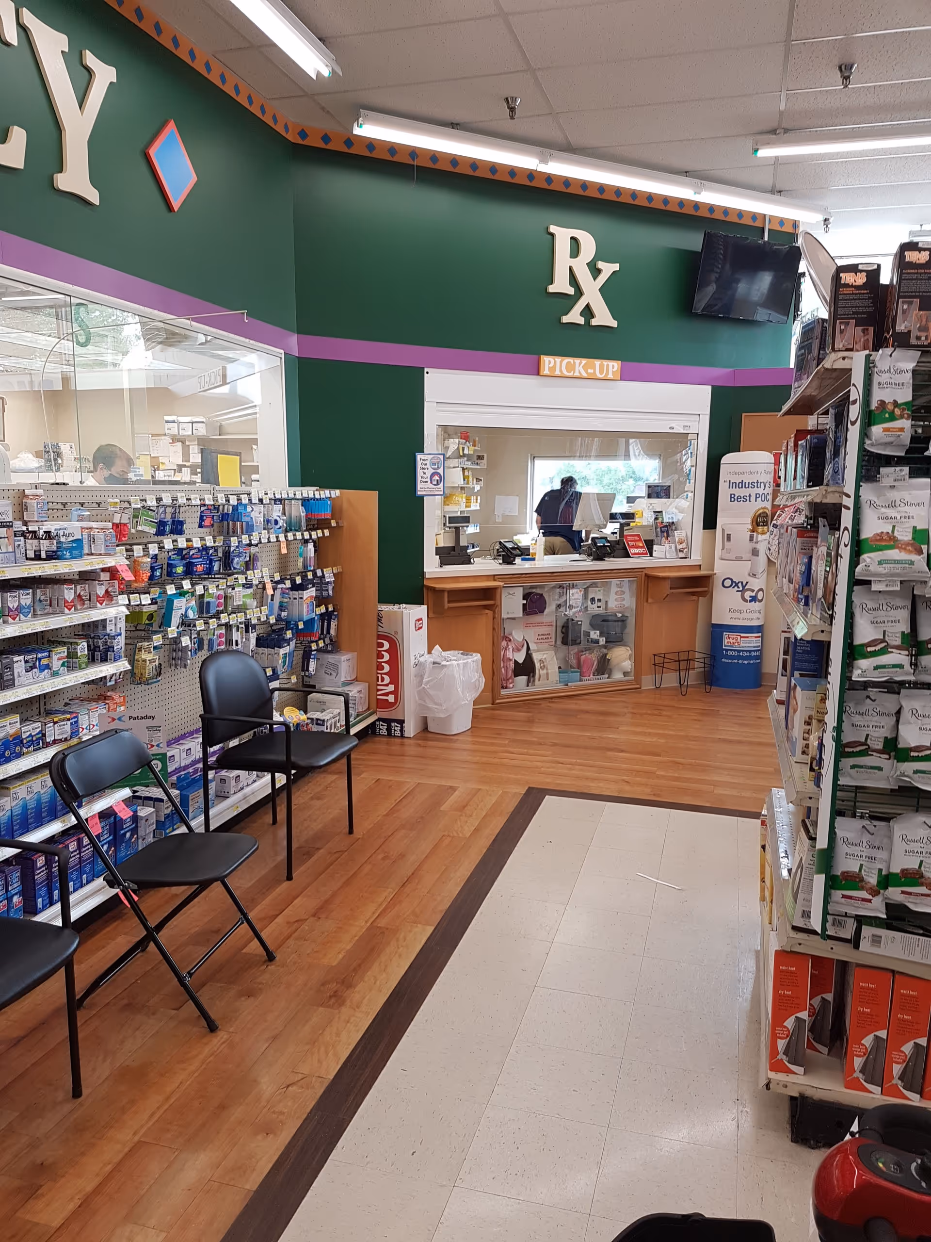 Interior of a Discount Drug Mart pharmacy with a pickup counter and shelves.